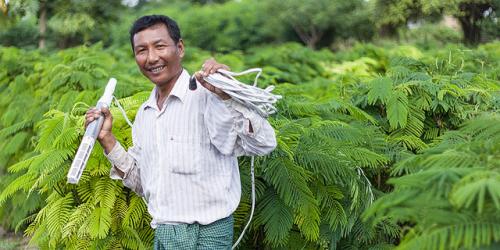 A farmer in Myanmar waters his crop with the help of a solar-powered irrigation pump. Credit: Ashden